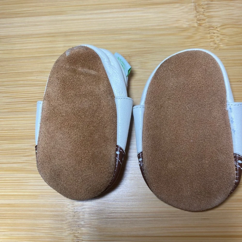 White and brown wingtip baby shoes